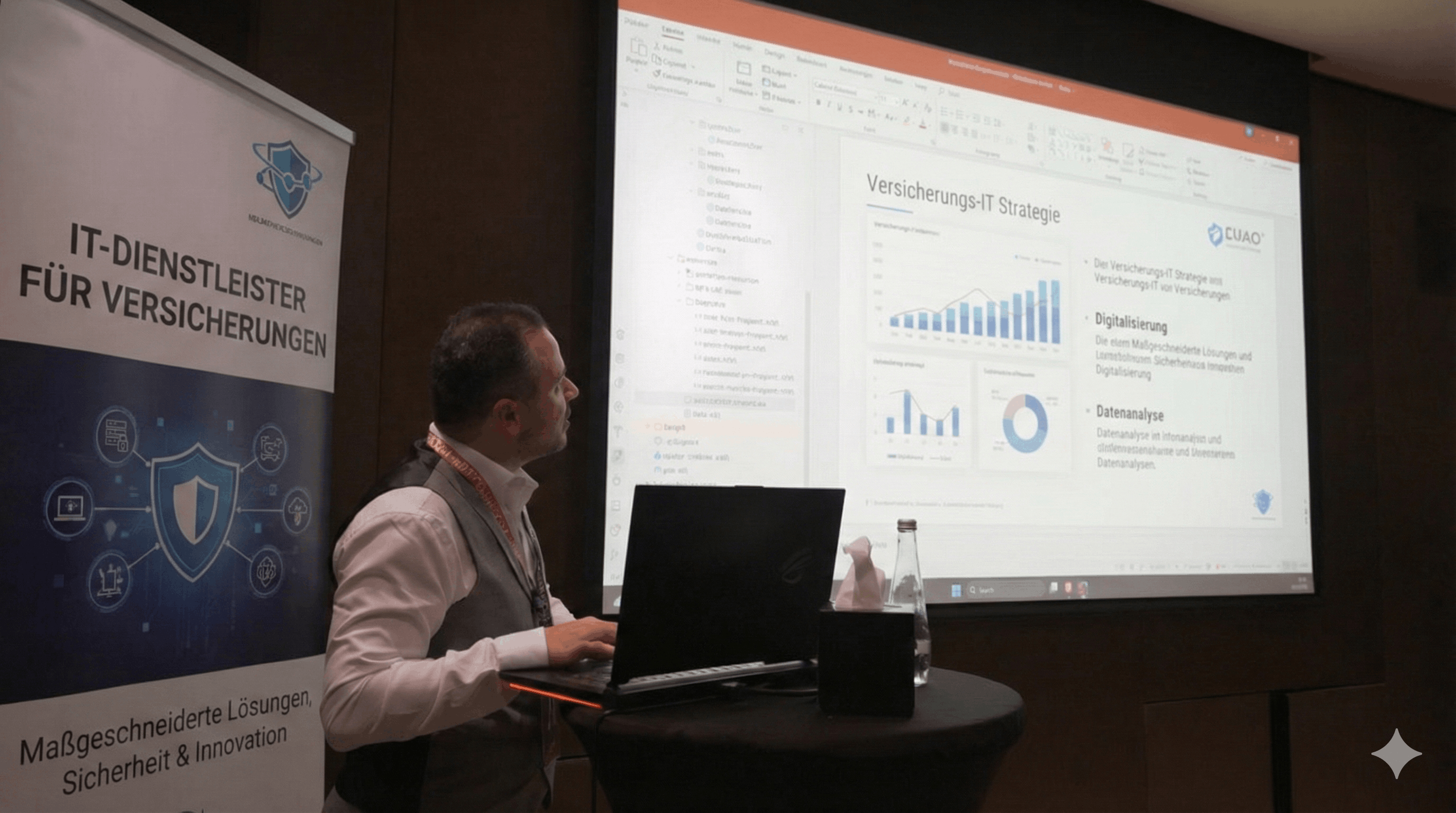 Ein Mann präsentiert eine Versicherung-IT-Strategie mit Diagrammen auf einem Projektor, neben einem Banner für IT-Dienstleister für Versicherungen.
